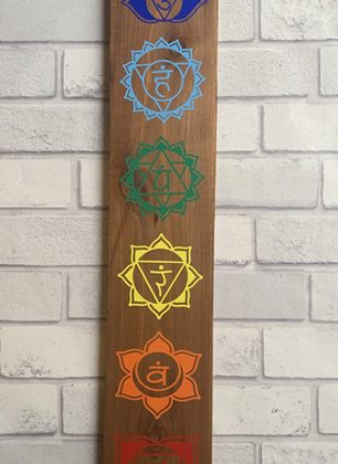 seven chakra symbols on a wooden board